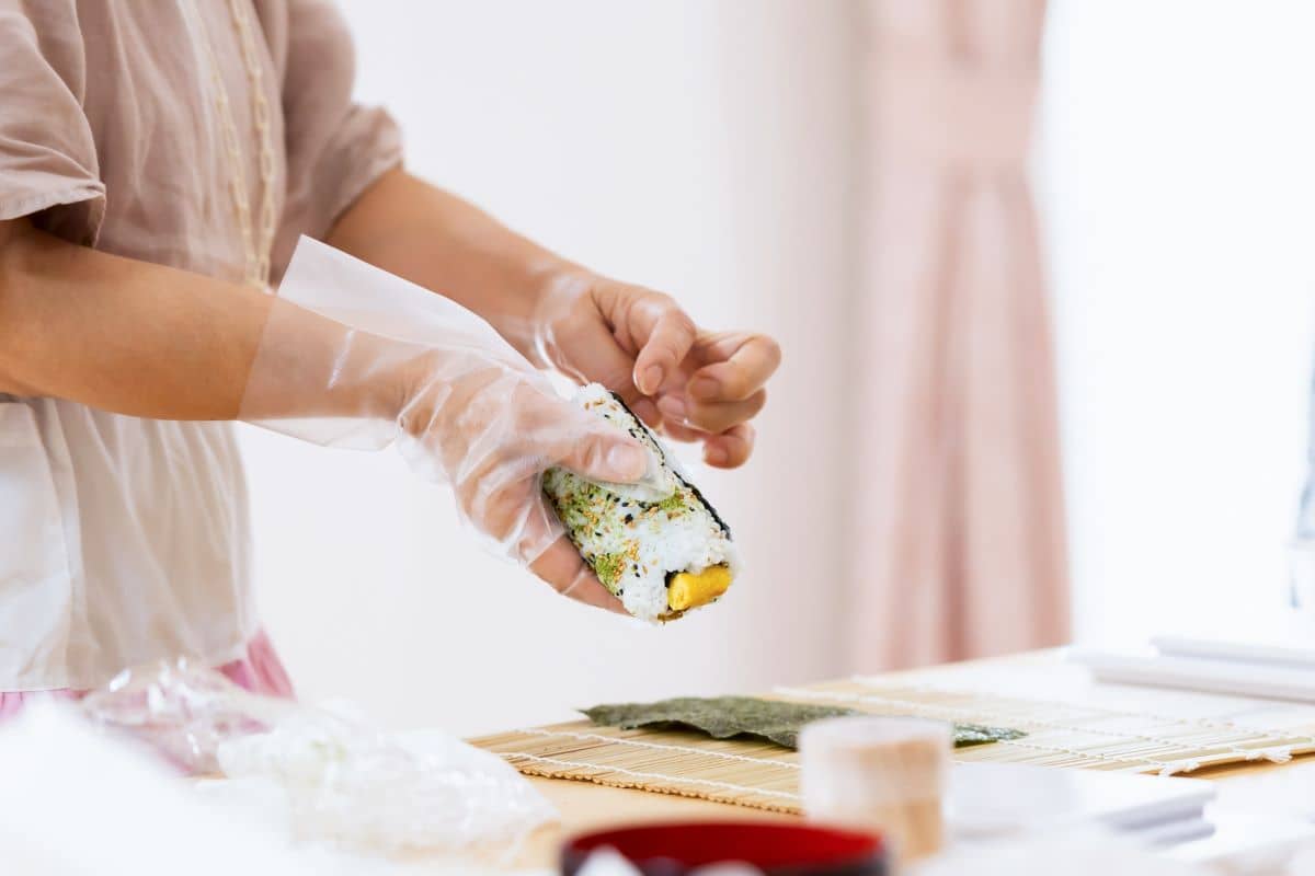 A woman making sushi rolls